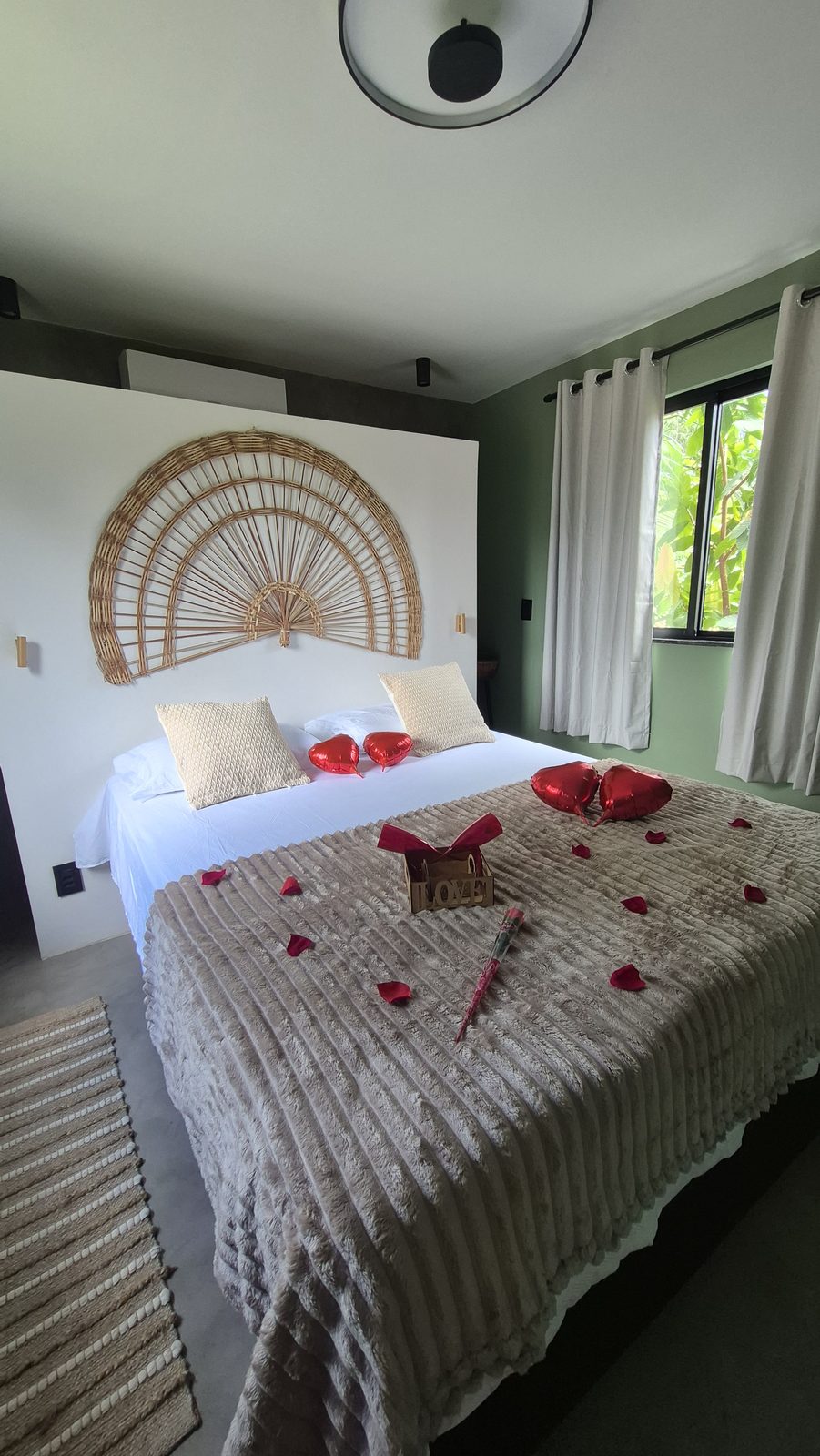 Cama decorada com pétalas e balões de coração
