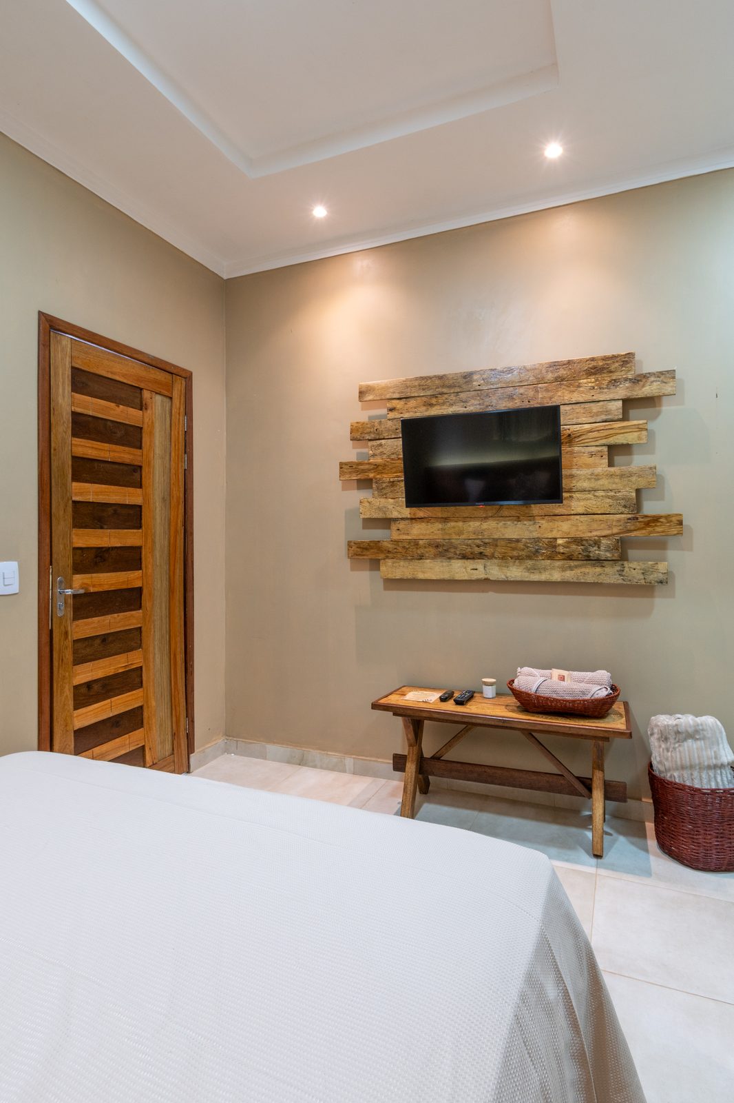 Quarto com painel de madeira e TV